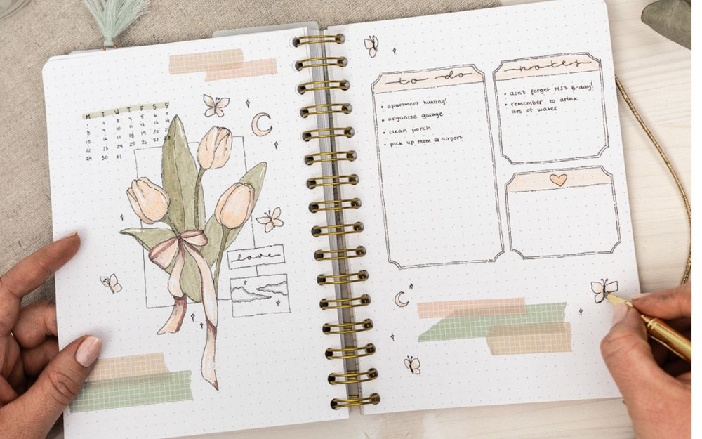 Ett bullet journal-uppslag med månadsplanering, blommor och listor
