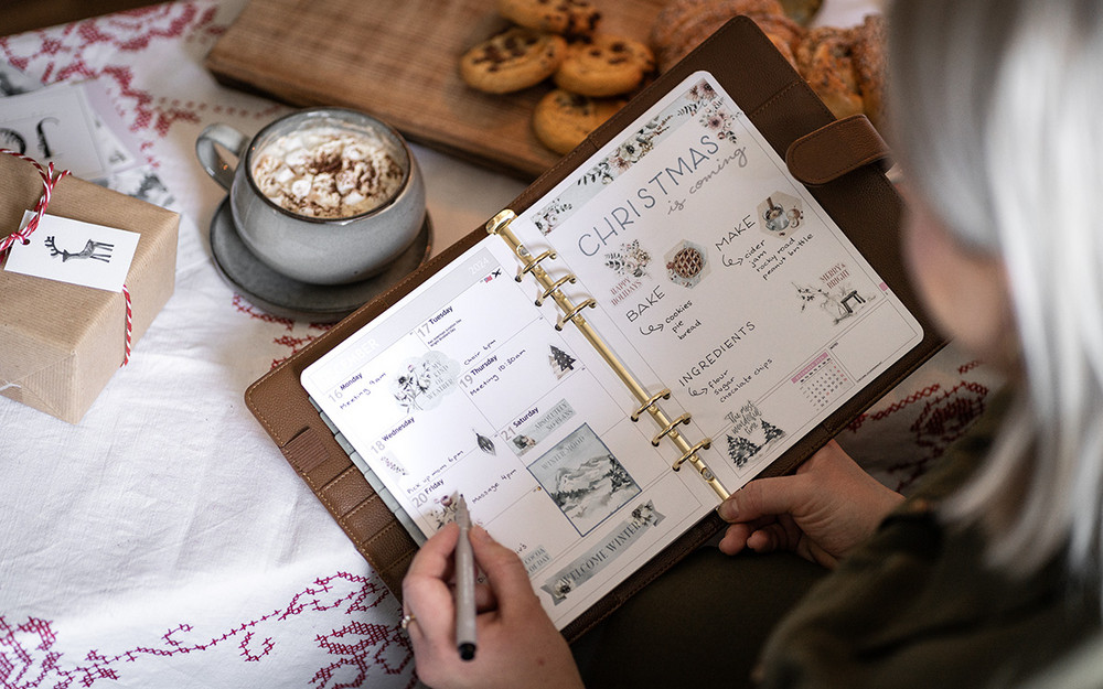 En åpen systemkalender fremfor et bord med kaffe og boller