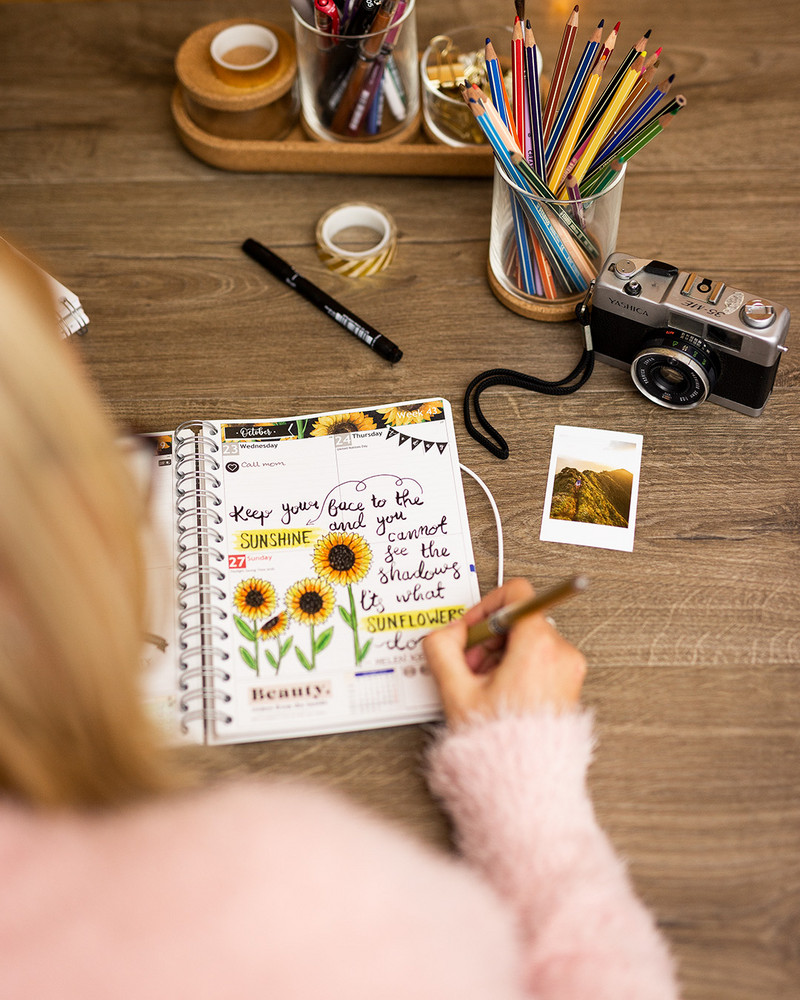 Desk with a personal planner and art supplies